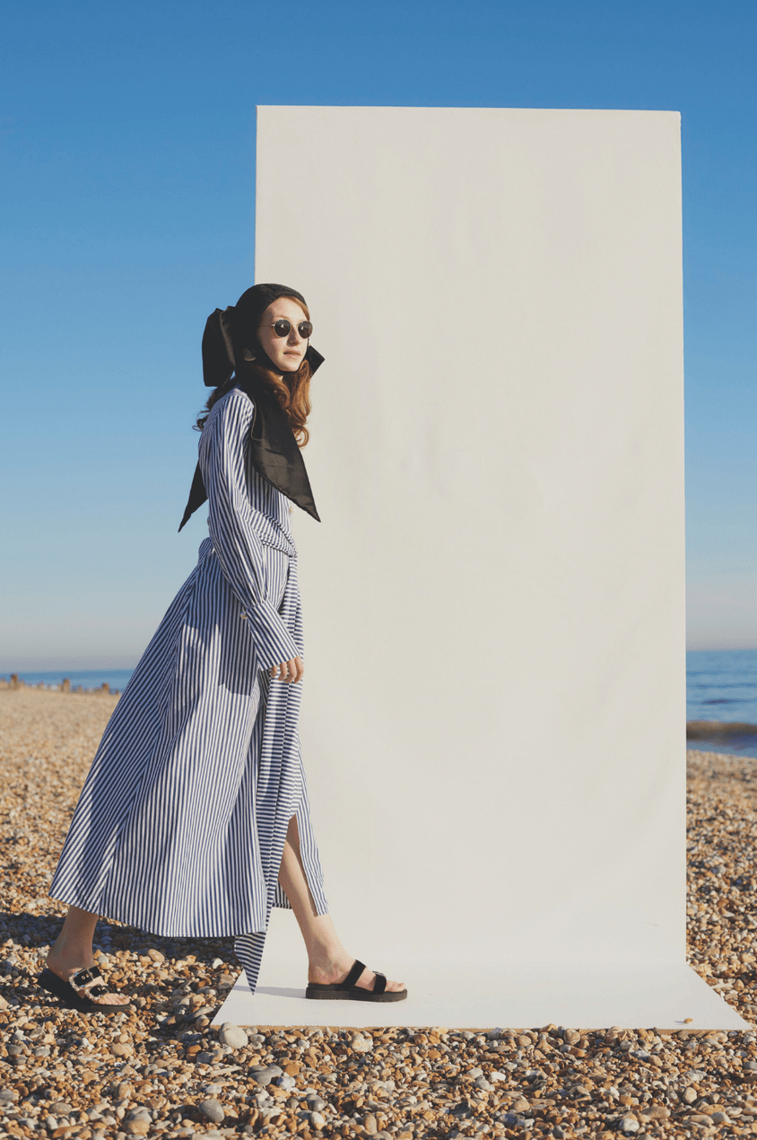 Model Wears Blue And White Striped Maxi Dress By Mother Of Pearl On A Beach